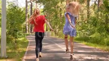 两个女朋友在绿色的夏季公园里奔跑跳跃，无忧无虑的少女们在夏季公园里嬉戏玩耍